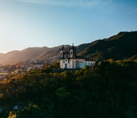 Centro histórico de Ouro Preto MG ao entardecer com igrejas coloniais.