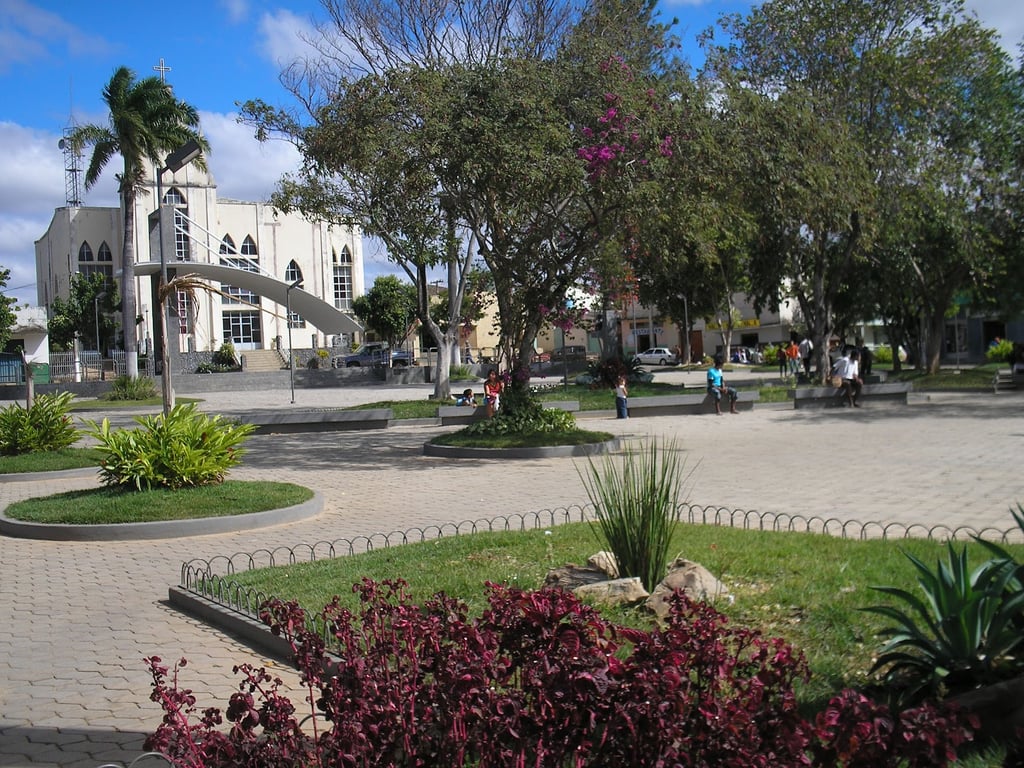 Centro de Francisco Sá MG, com praça, igreja e áreas verdes em cena urbana