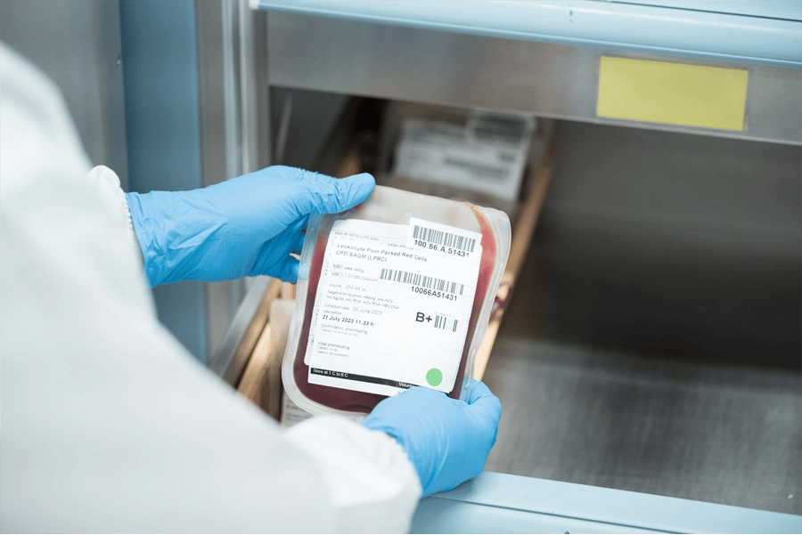 Profissional de laboratório manipulando amostras de sangue em ambiente moderno