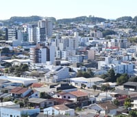Vista panorâmica de São Lourenço do Oeste SC ao final da tarde, com prédios baixos e áreas verdes.