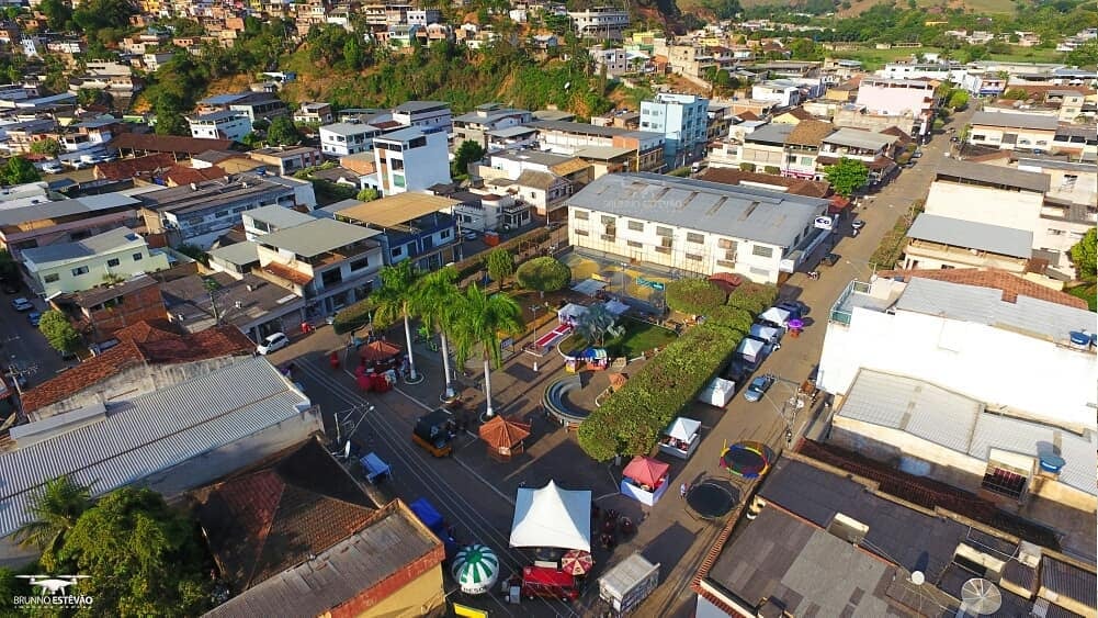 Vista aérea de cidade da Zona da Mata de Minas Gerais, com morros verdes e casario típico