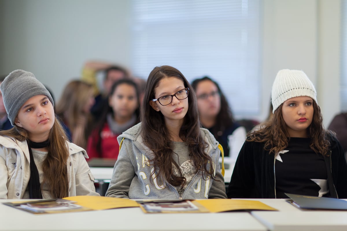 Sala de aula moderna, com professor e estudantes em ambiente iluminado
