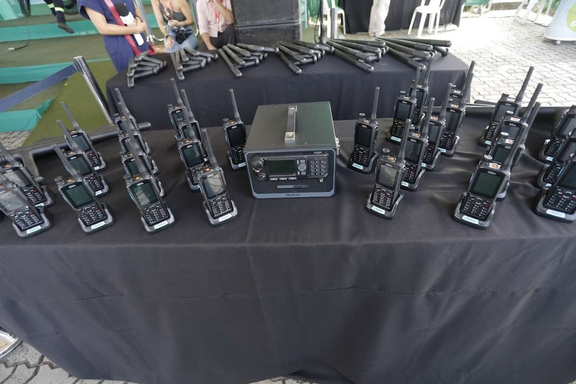 Rádios comunicadores em mesa de evento institucional de segurança pública; imagem ilustrativa para GCM