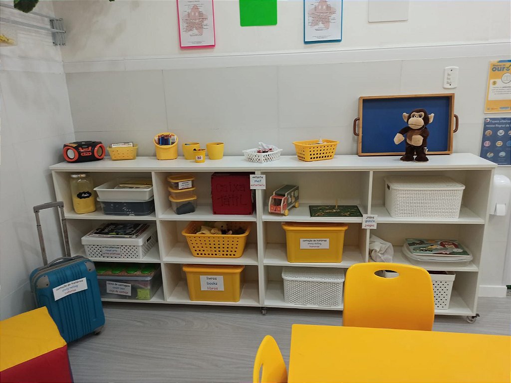Sala de aula de educação infantil com brinquedos e mesas coloridas