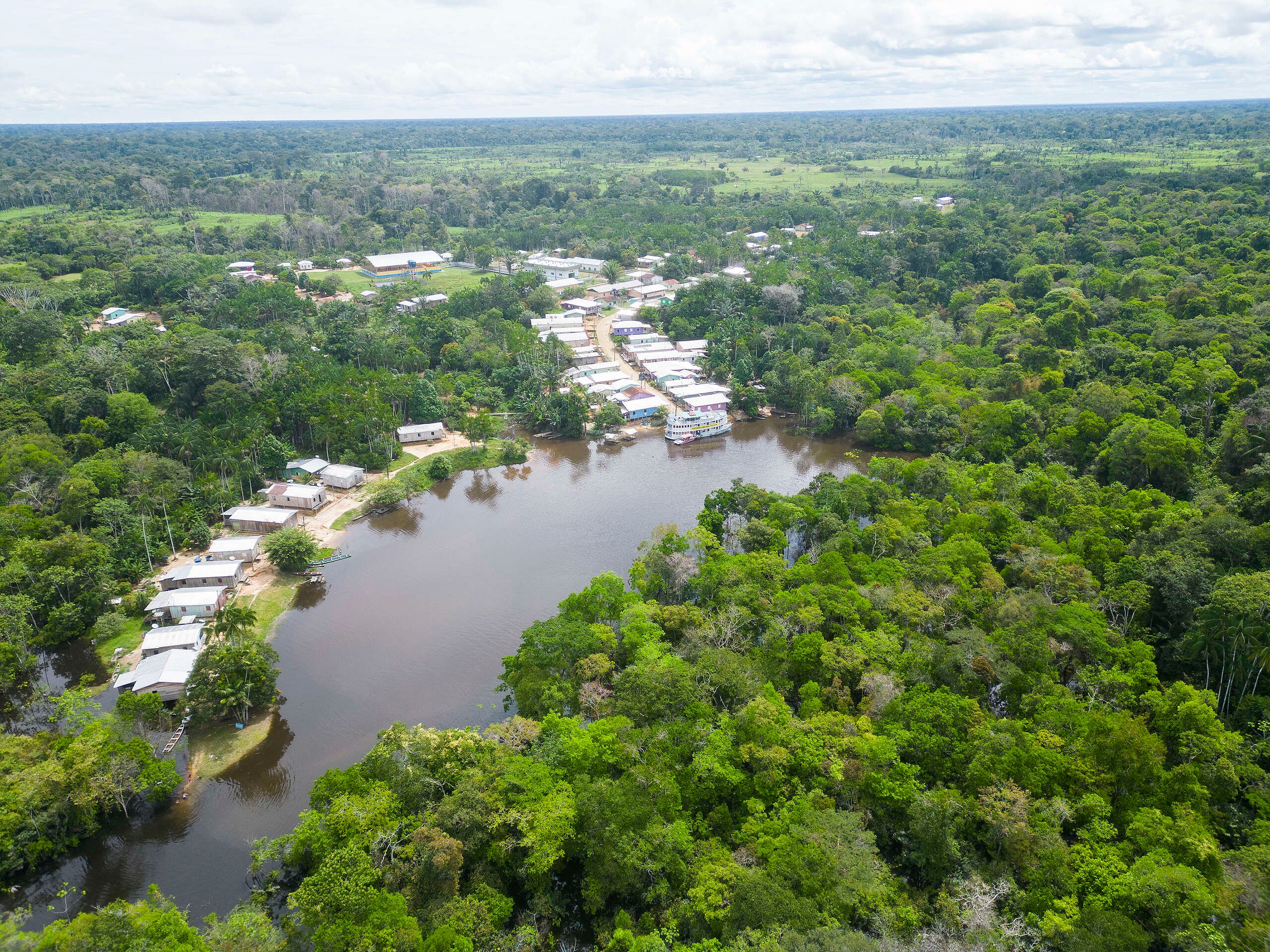 Vista aérea do rio Juruá com floresta densa e comunidades ribeirinhas