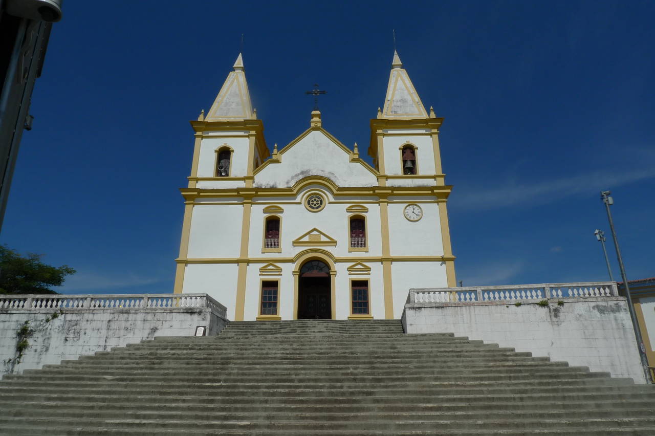 Igreja matriz de Perdigão MG em dia claro, fachada com escadaria; cena urbana típica do interior mineiro