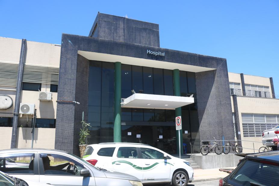 Imagem genérica de fachada hospitalar com movimento de carros em dia ensolarado