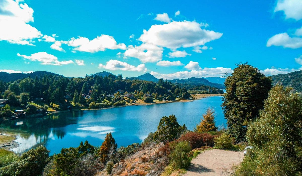 Paisagem da região central do RS, com morros e vegetação ao redor de espelho d’água