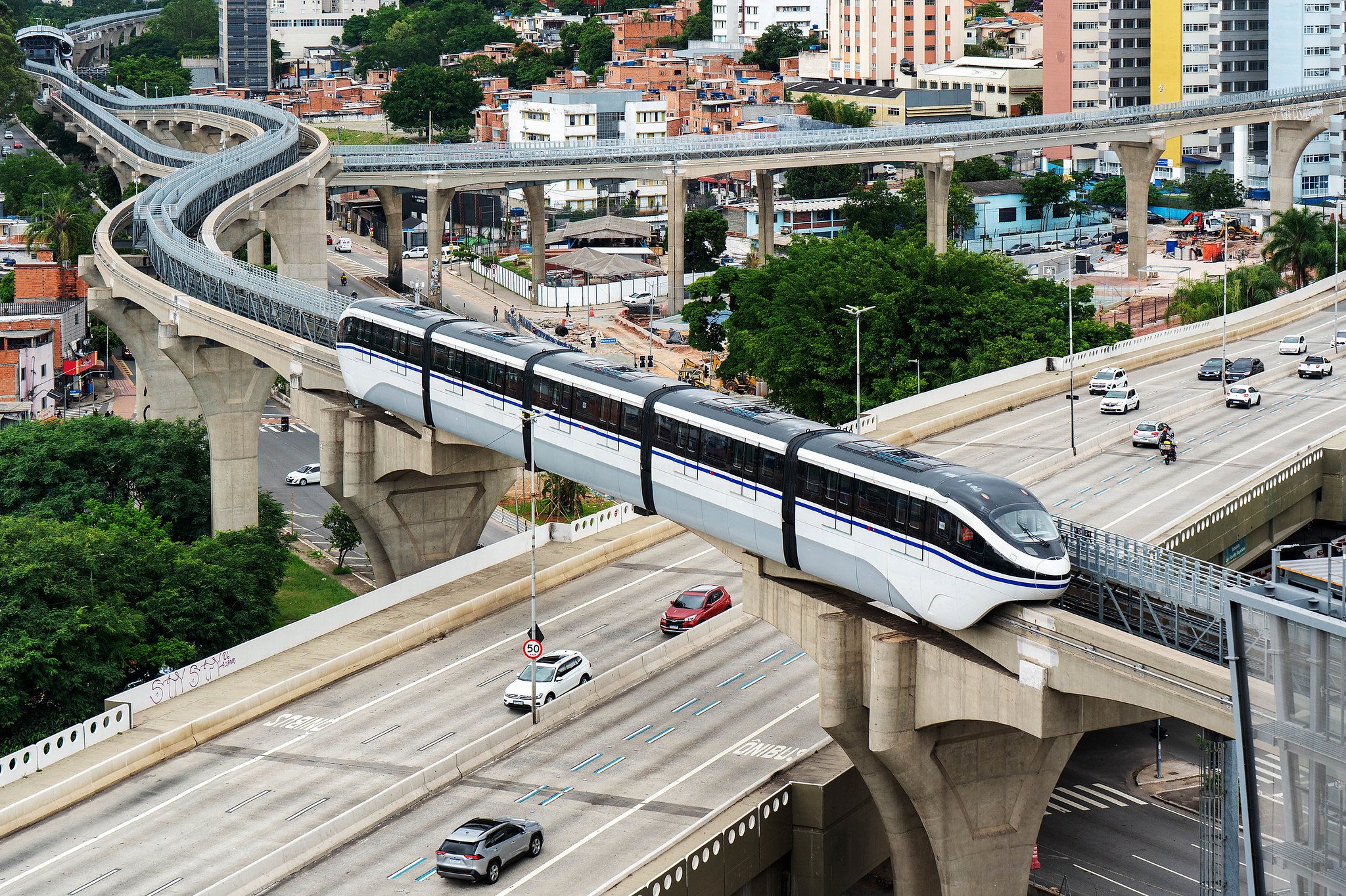 Infraestrutura de transporte urbano em São Paulo, com trem elevado e avenida com tráfego