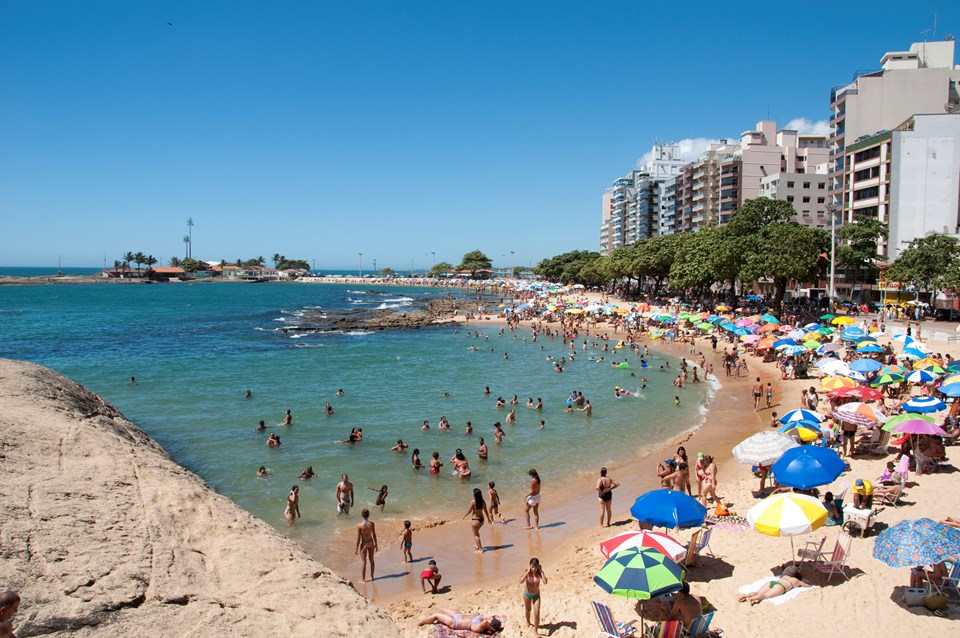 Vista aérea da praia de Piúma, no Espírito Santo, com faixa de areia, mar e área urbana ao fundo