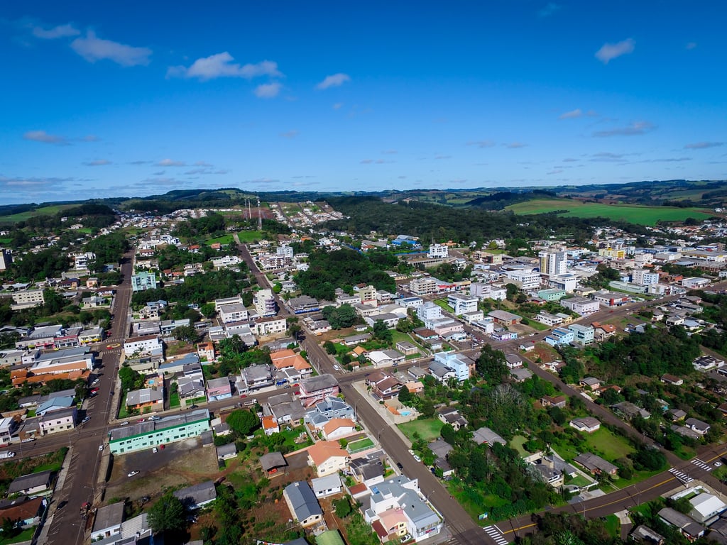 Vista aérea de pequena cidade no Sul do Brasil, com relevo suave e área urbana ao entardecer