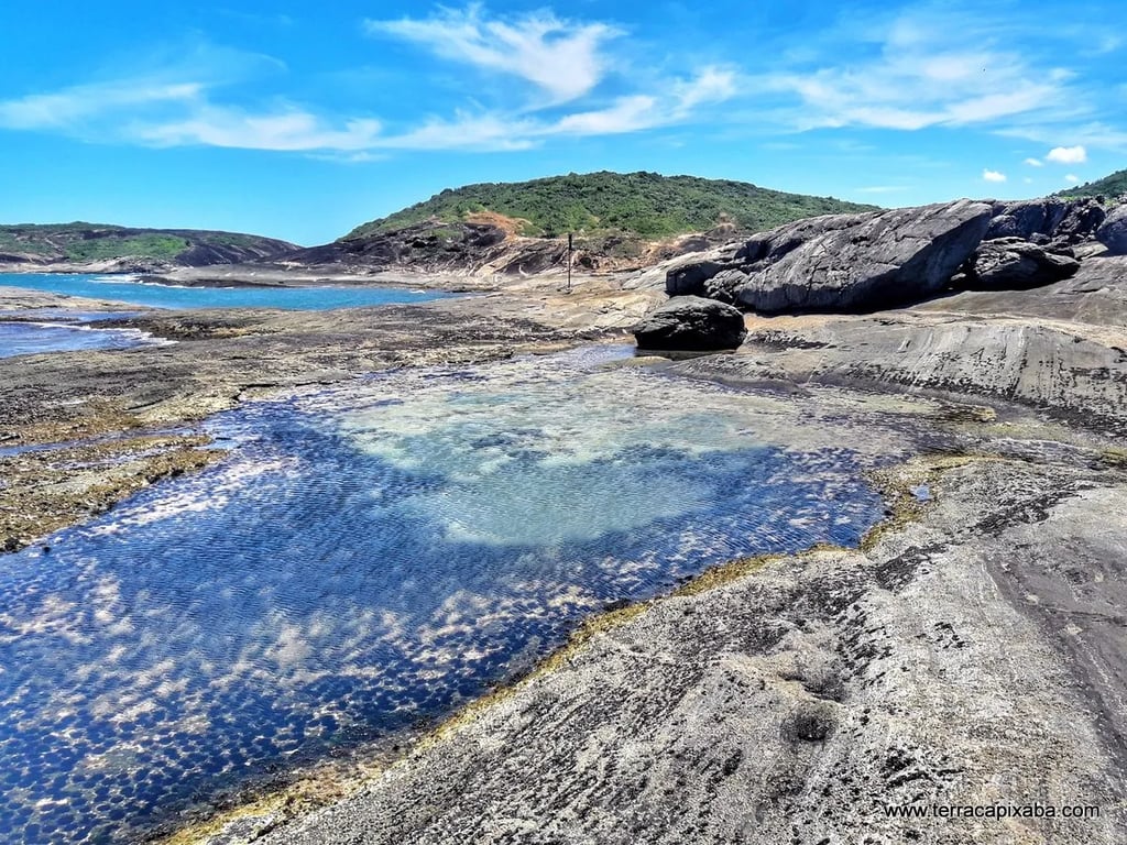 Paisagem costeira no litoral do Espírito Santo, com rochas e vegetação atlântica ao fim da tarde