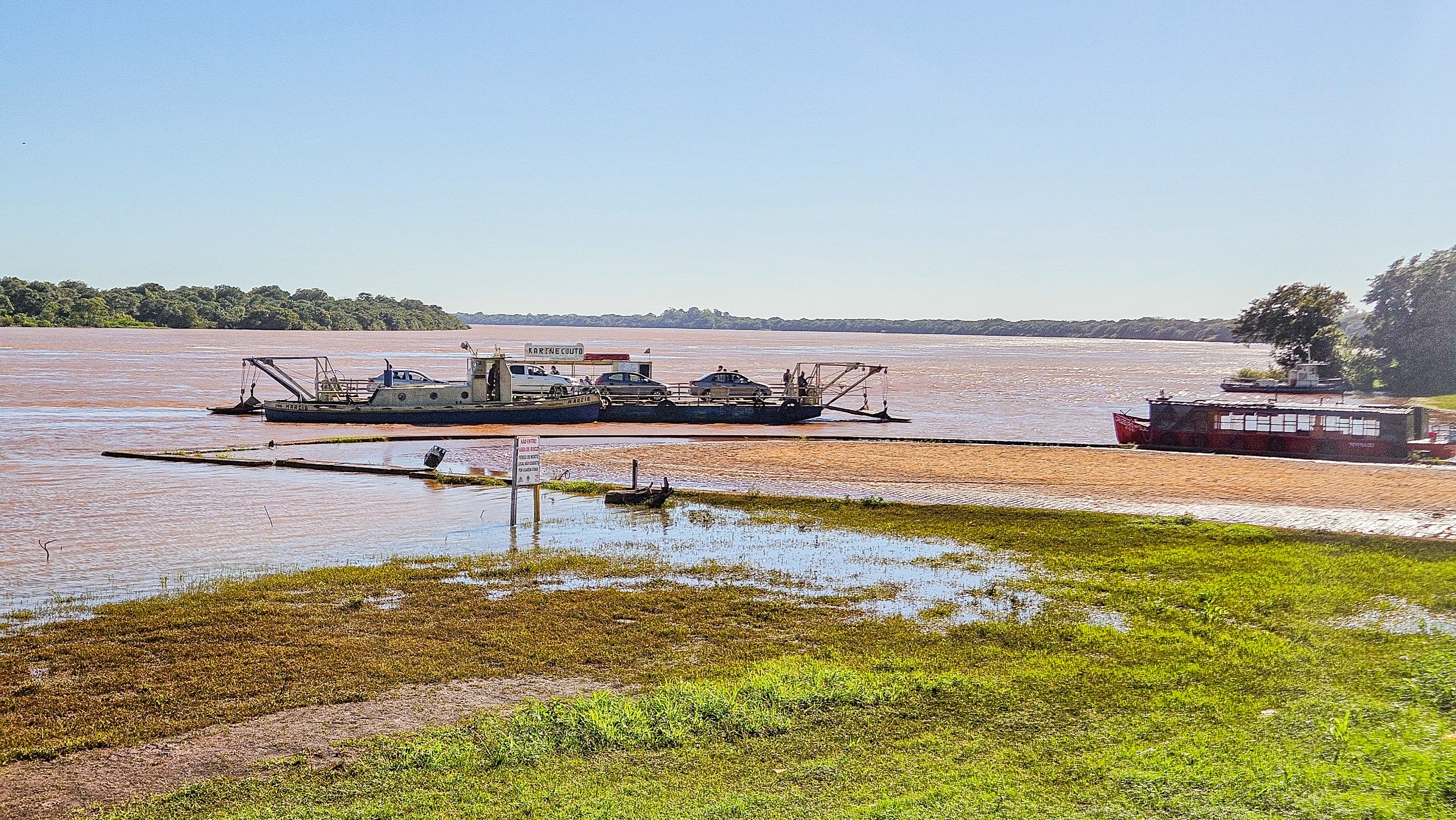 Vista do Rio Uruguai em Itaqui RS, com embarcações e margem arborizada ao entardecer