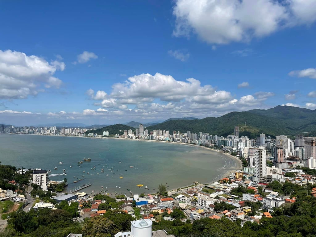 Vista aérea de Itapema (SC), com mar azul e orla urbana em dia ensolarado