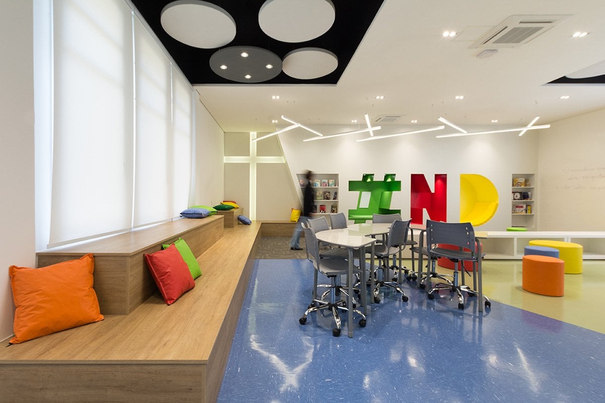 Ambiente acadêmico com laboratório de informática moderno e espaço colaborativo, sugerindo a rotina de aulas práticas na área de TI
