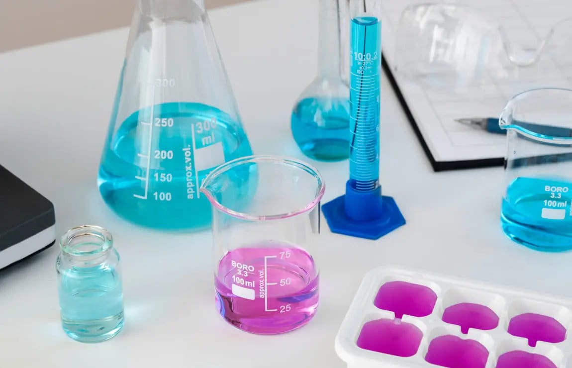 Laboratório acadêmico de Química, com vidrarias e reagentes sobre bancadas, iluminação moderna