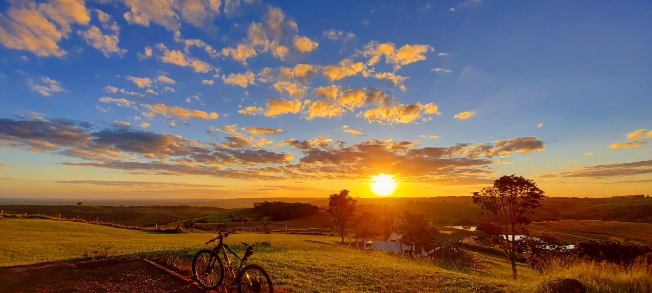 Estrada rural no interior de São Paulo ao entardecer, composição horizontal ampla