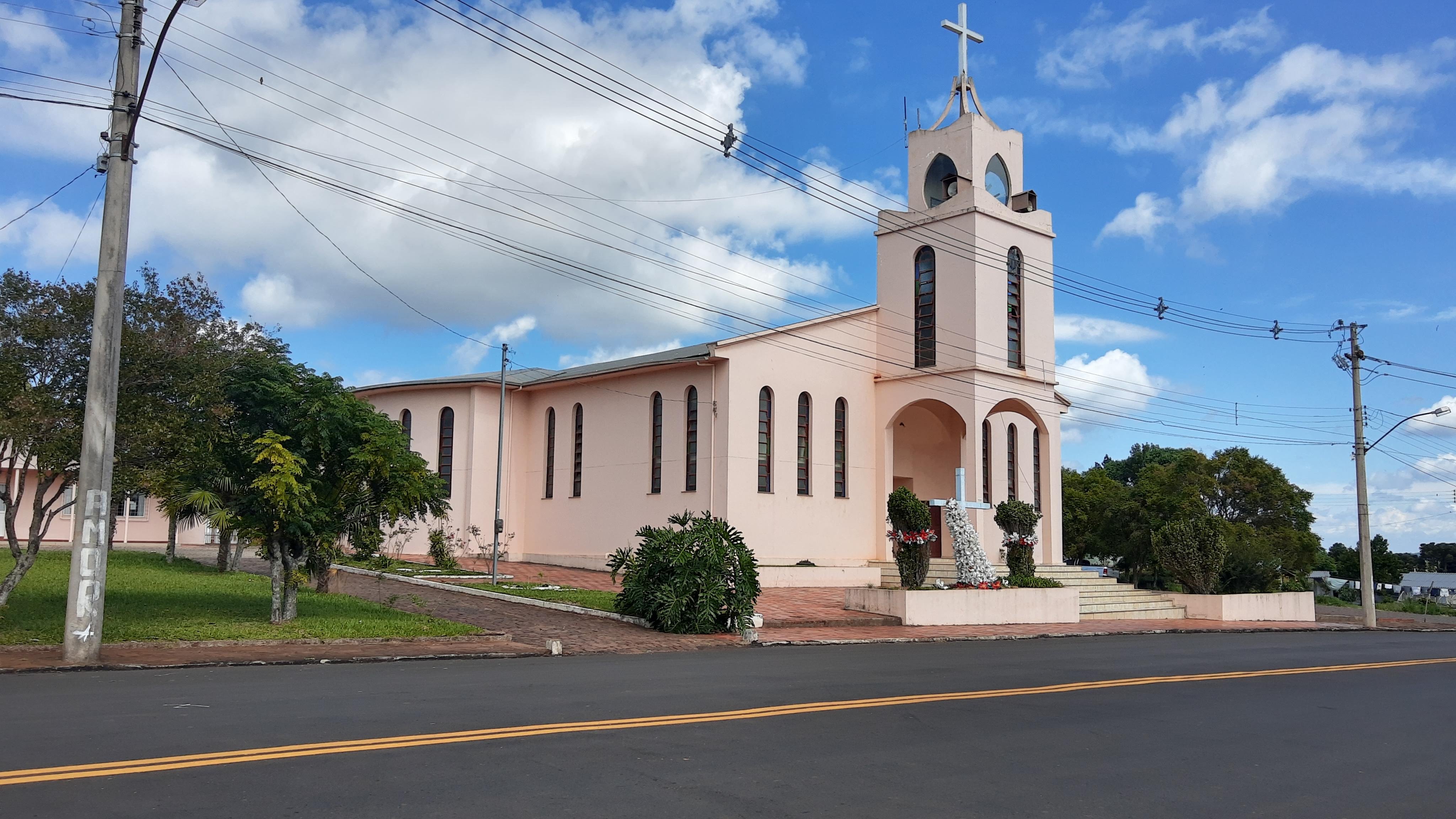 Paisagem urbana no interior do RS, com edifício histórico e céu azul ao fundo