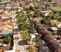 Vista aérea da área central de Abre Campo MG, com igreja e praça ao fundo.