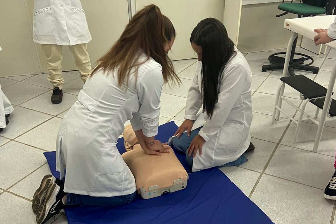 Aula prática de enfermagem com manequim de simulação em laboratório didático