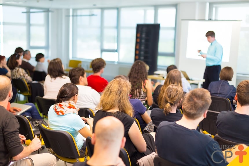 Sala de aula moderna com apresentação de gráficos financeiros, ilustrando aula de Contabilidade