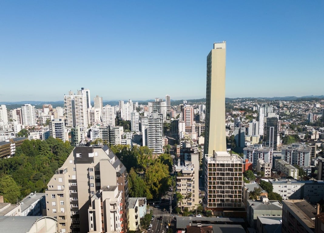 Vista urbana de Caxias do Sul com áreas verdes em dia claro