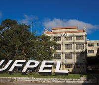 Fachada do prédio histórico da Reitoria da UFPel com jardins ao redor.