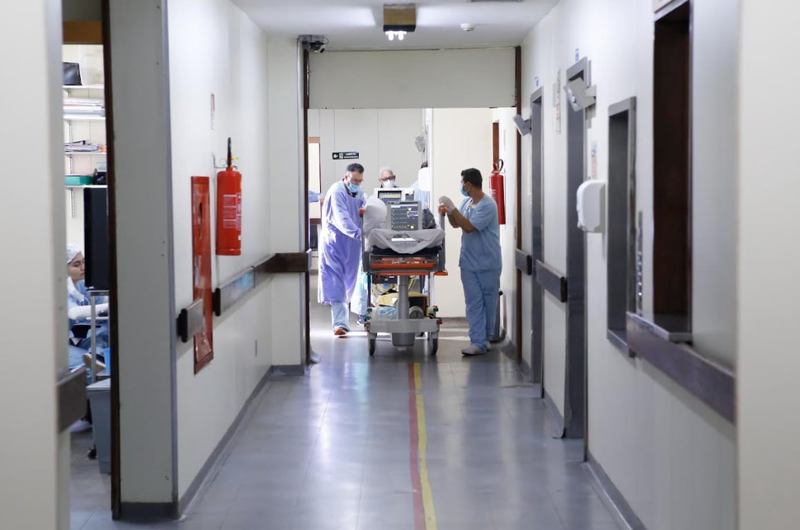 Profissionais de saúde em corredor de hospital, equipe diversa