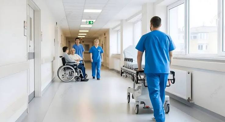 Equipe de profissionais de saúde em corredor hospitalar moderno