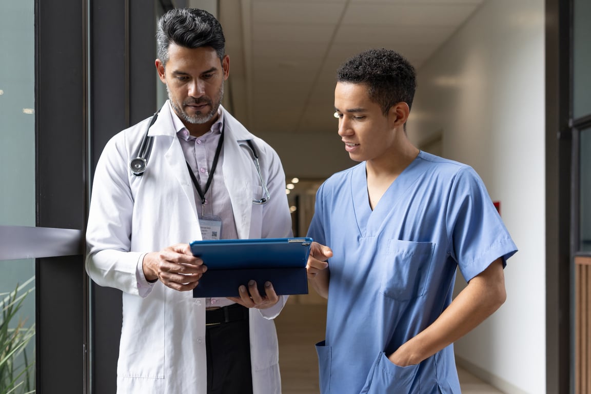 Profissionais de saúde conversando em corredor de clínica, em formato horizontal.