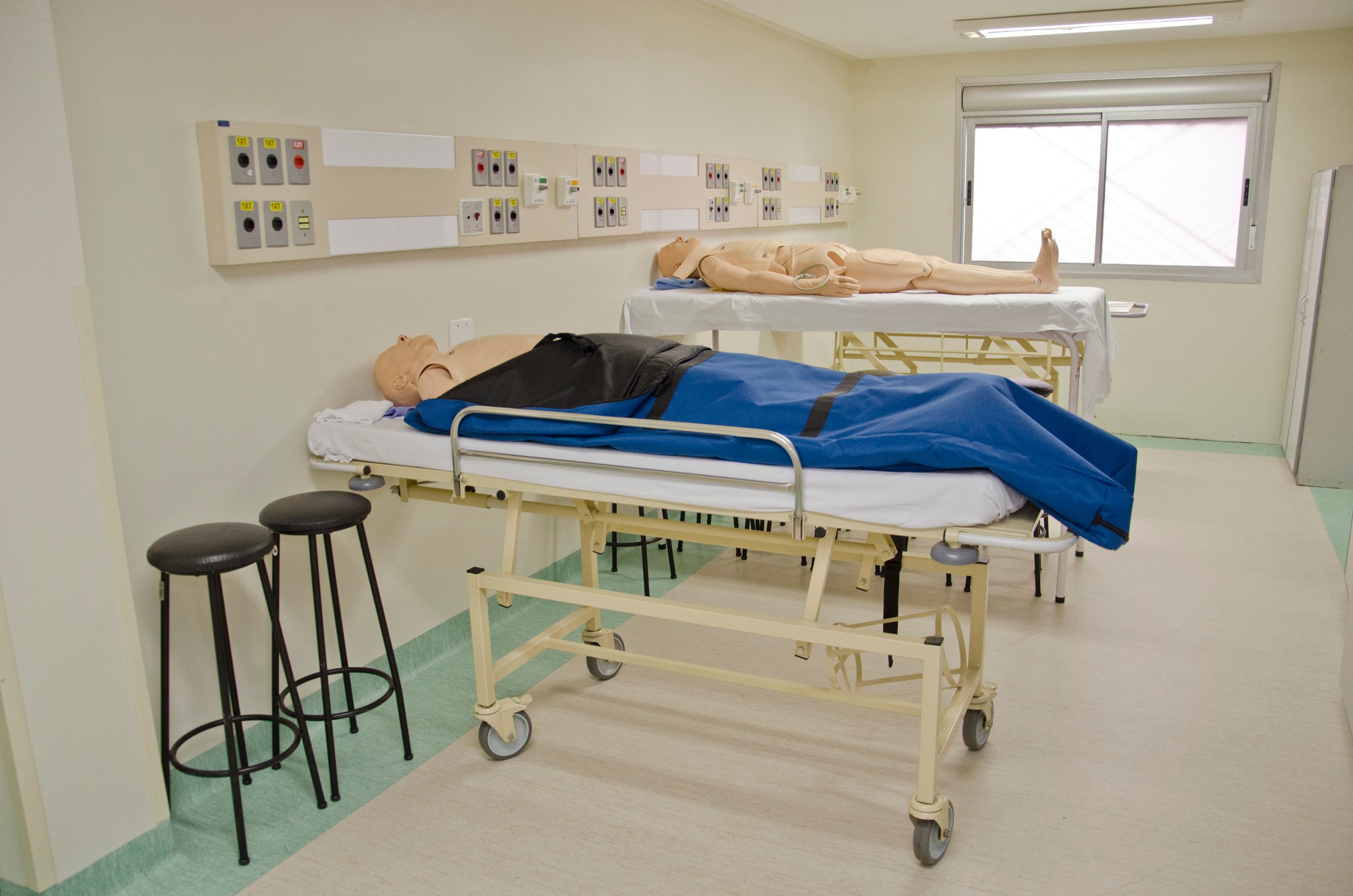 Laboratório de Enfermagem com manequins e materiais de simulação clínica, organizado para atividades de ensino.