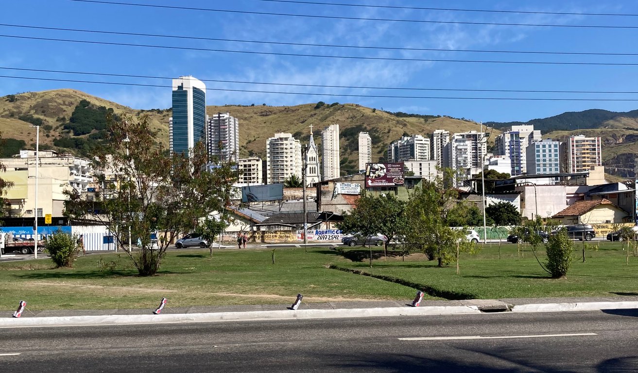 Fachada de prédio público em área urbana, com circulação de pessoas em dia claro