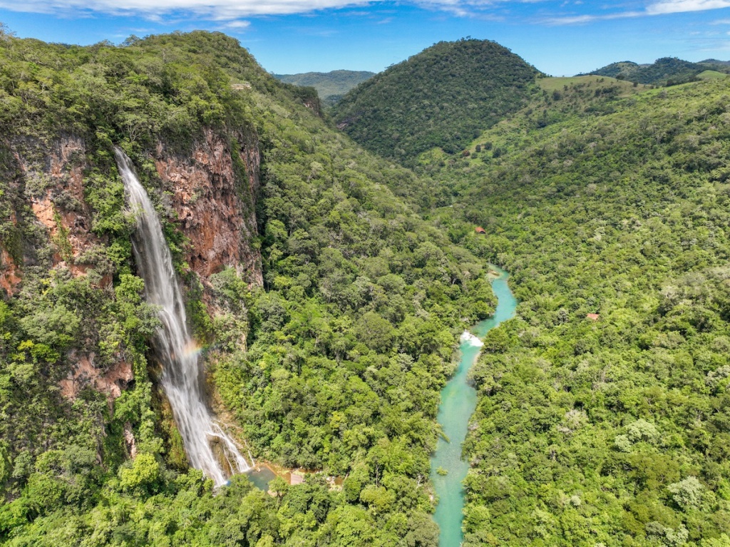 Paisagem natural do Mato Grosso do Sul, com vegetação e água corrente, ao entardecer