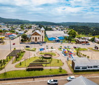 Vista aérea da área central de Francisco Alves PR, com praça e igreja.