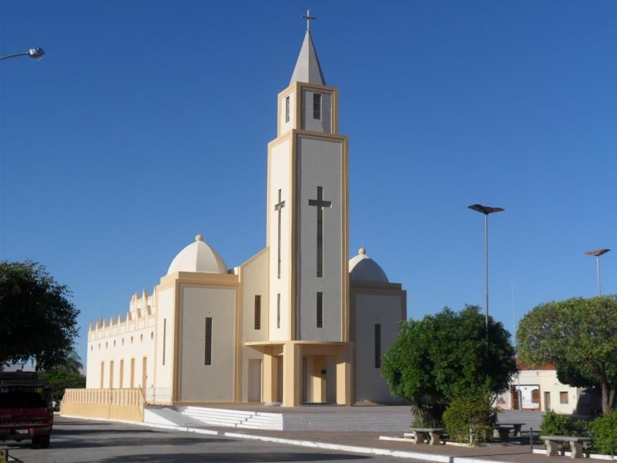 Paisagem urbana de Pio IX PI, com igreja e praça central sob céu azul, no semiárido piauiense