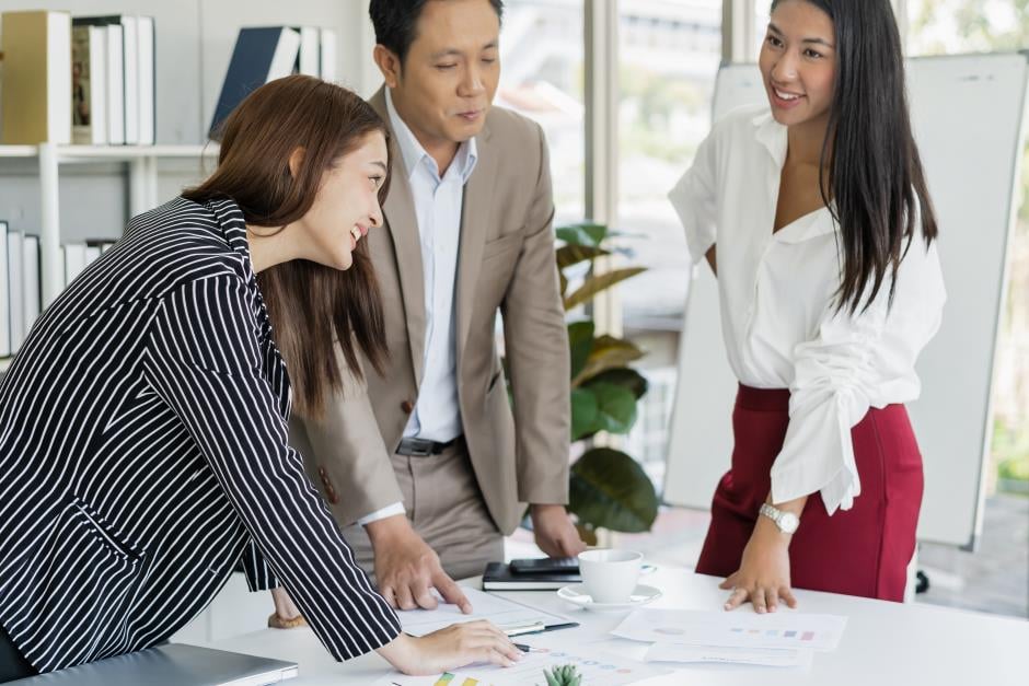 Profissionais em reunião analisando documentos em escritório moderno