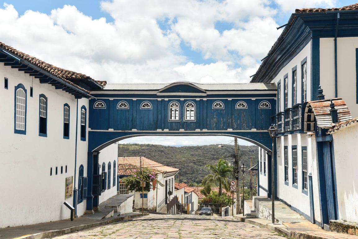 Rua de cidade histórica de Minas Gerais, com casario colonial sob céu azul