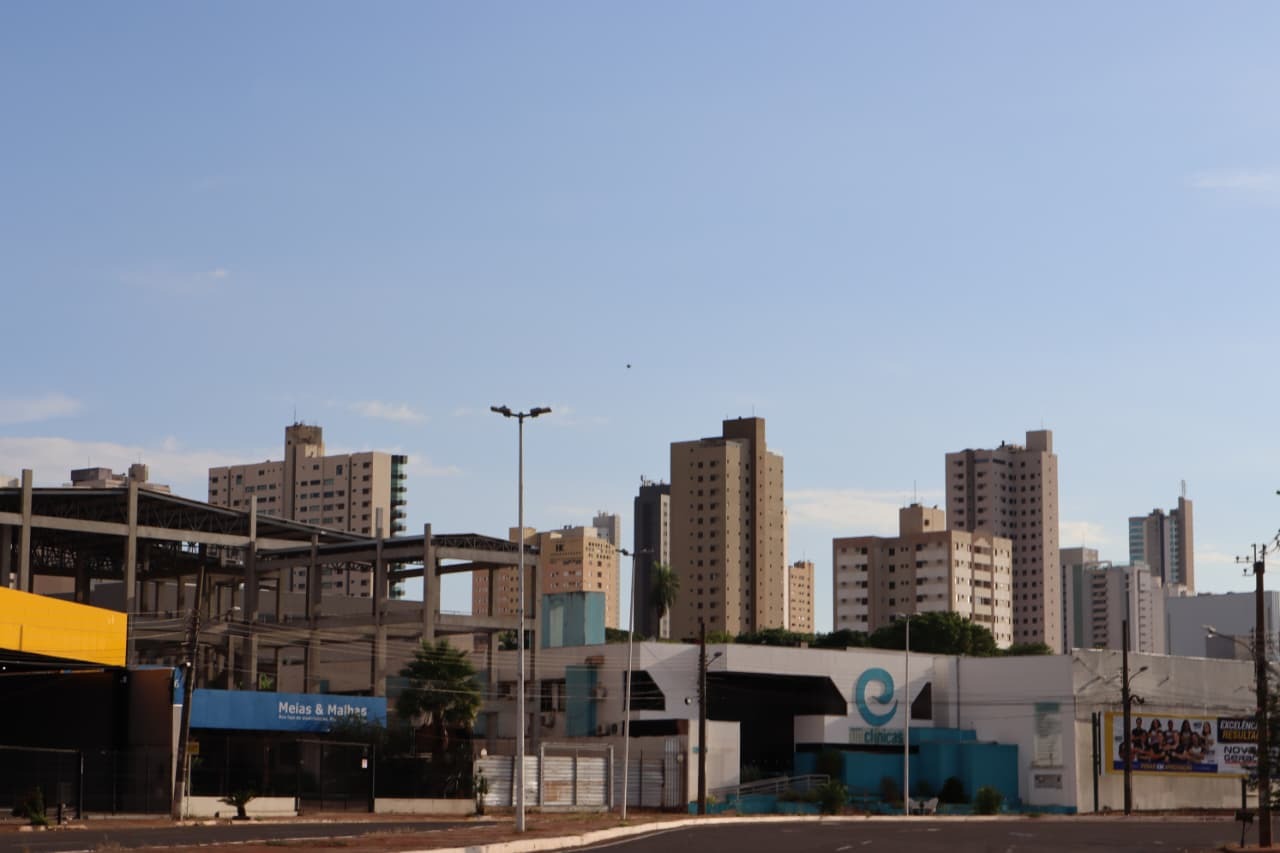 Vista aérea de cidade de pequeno porte com céu azul e área urbana em destaque