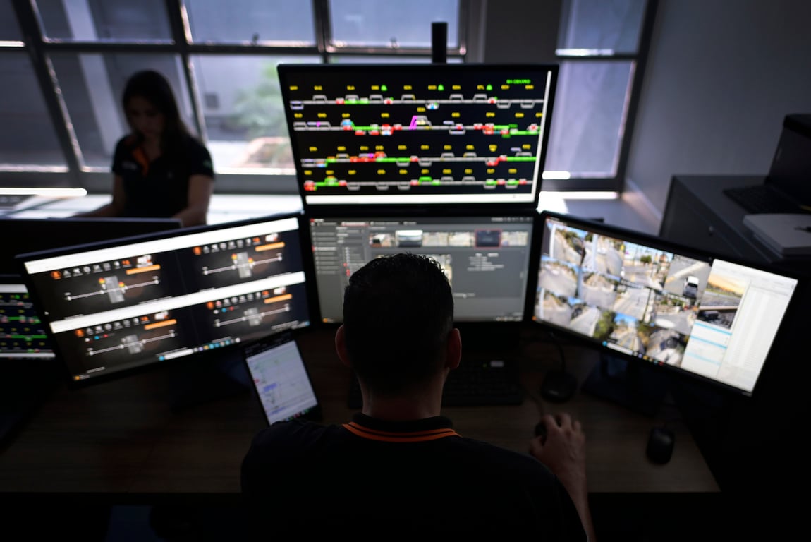 Centro de controle de operações ferroviárias, com painéis e operadores em atividade