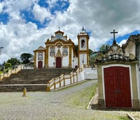 Vista aérea do centro histórico de São João del-Rei, com igrejas coloniais e telhados de cerâmica.