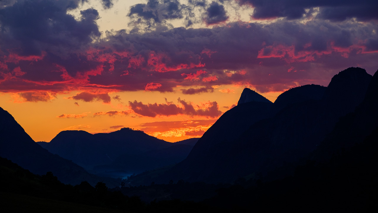 Paisagem de Pancas ES ao entardecer, com pontões rochosos ao fundo