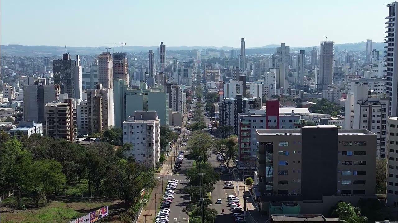 Vista urbana de Chapecó (SC) ao entardecer, com prédios e avenida arborizada; cidade onde serão aplicadas as provas do concurso de Guatambu.