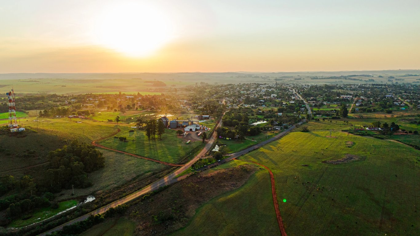 Estradas e áreas verdes ao pôr do sol, paisagem rural ampla em região montanhosa