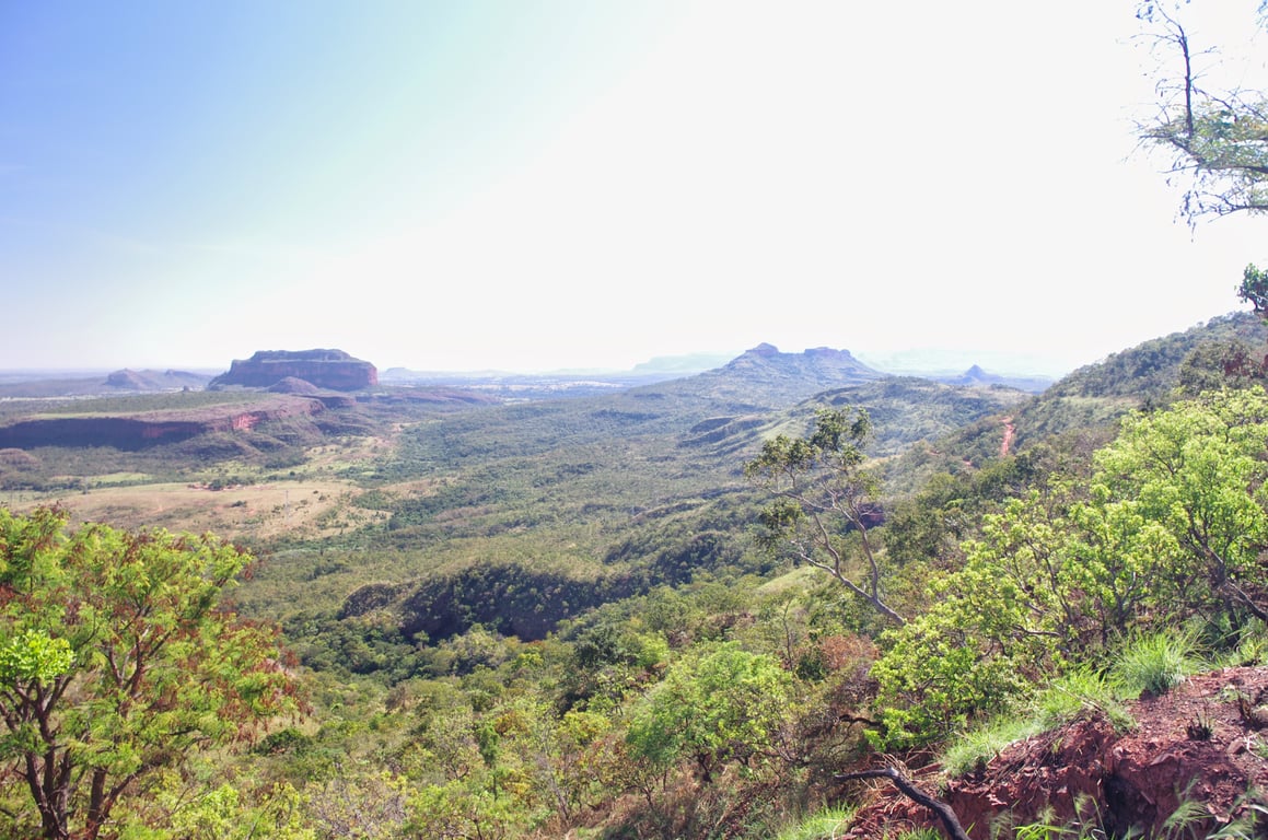 Vista aérea de região de cerrado com área urbana ao fundo, remetendo a municípios do interior de Mato Grosso