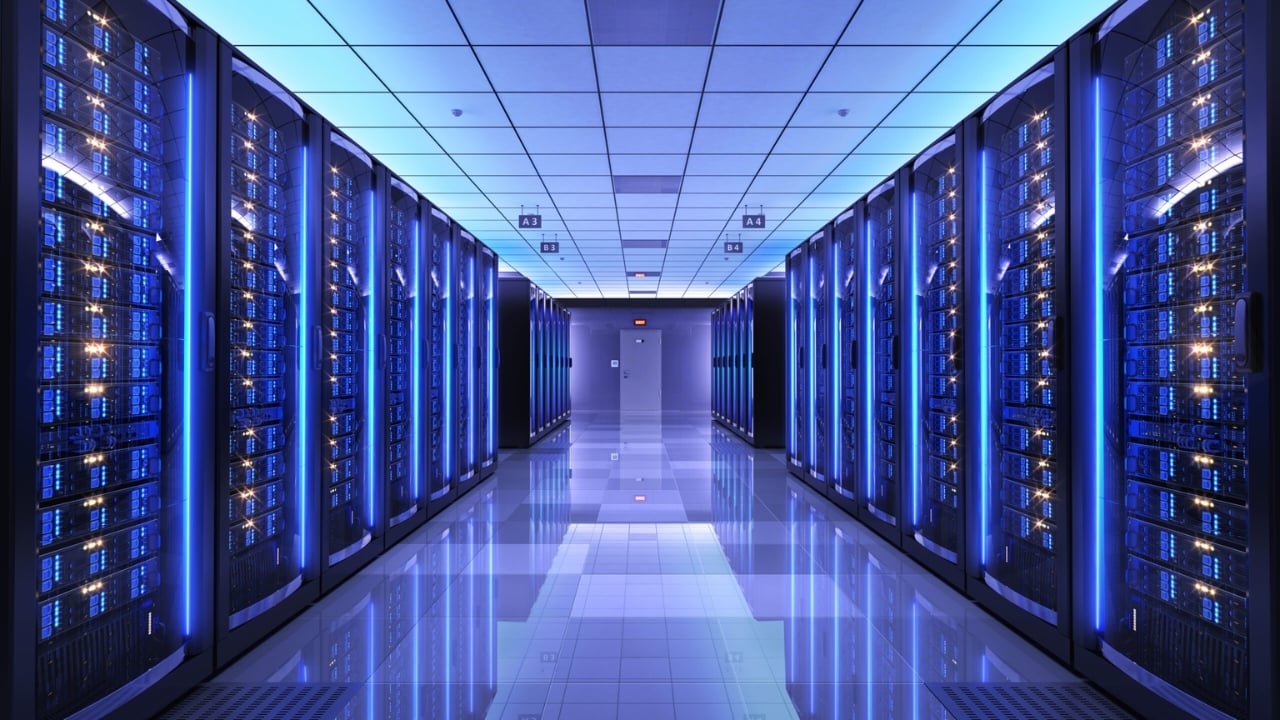 Sala de servidores com racks e switches organizados, iluminada por luz azul