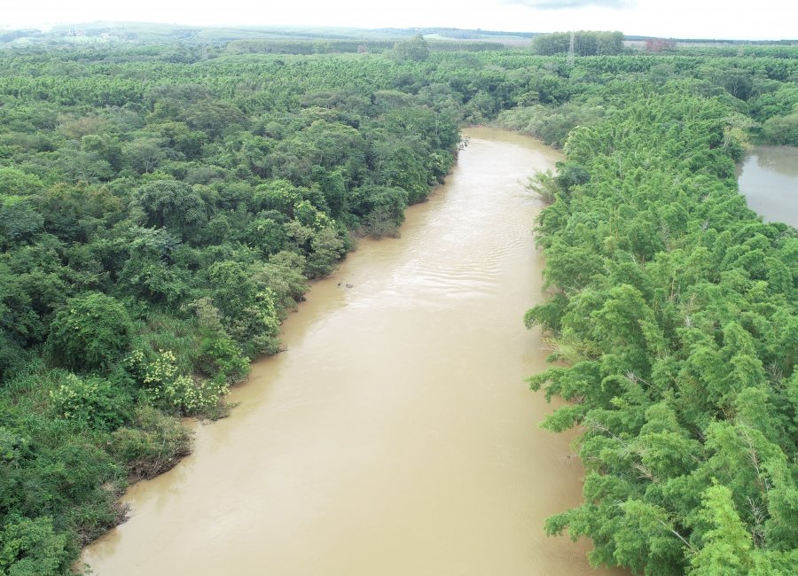Vista aérea do rio Mogi Guaçu, com vegetação e área urbana ao fundo