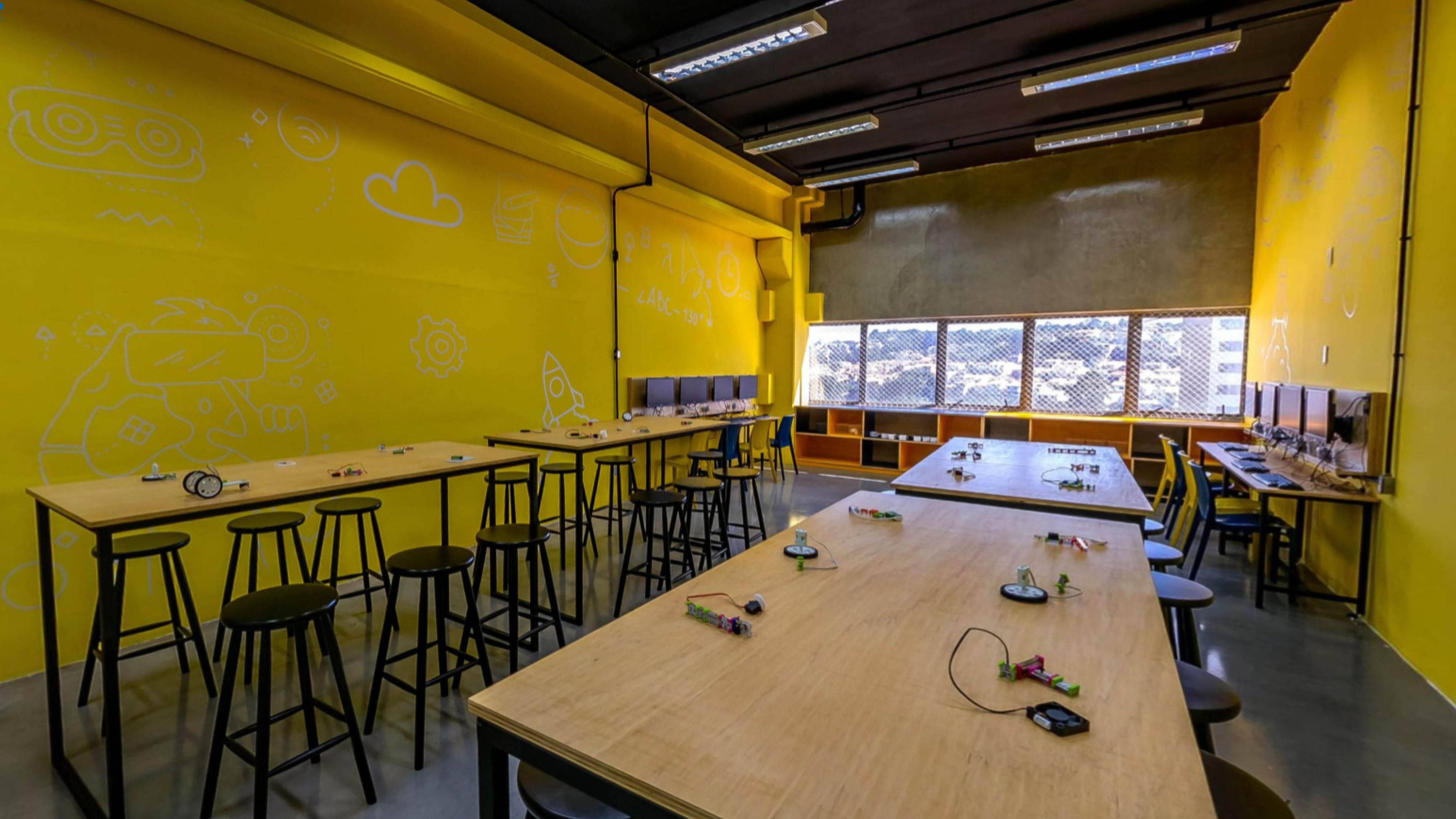 Ambiente acadêmico: laboratório universitário moderno, mesas e equipamentos, composição horizontal
