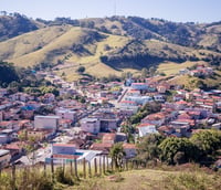 Centro de Tocos do Moji MG, com morros e vegetação ao redor.
