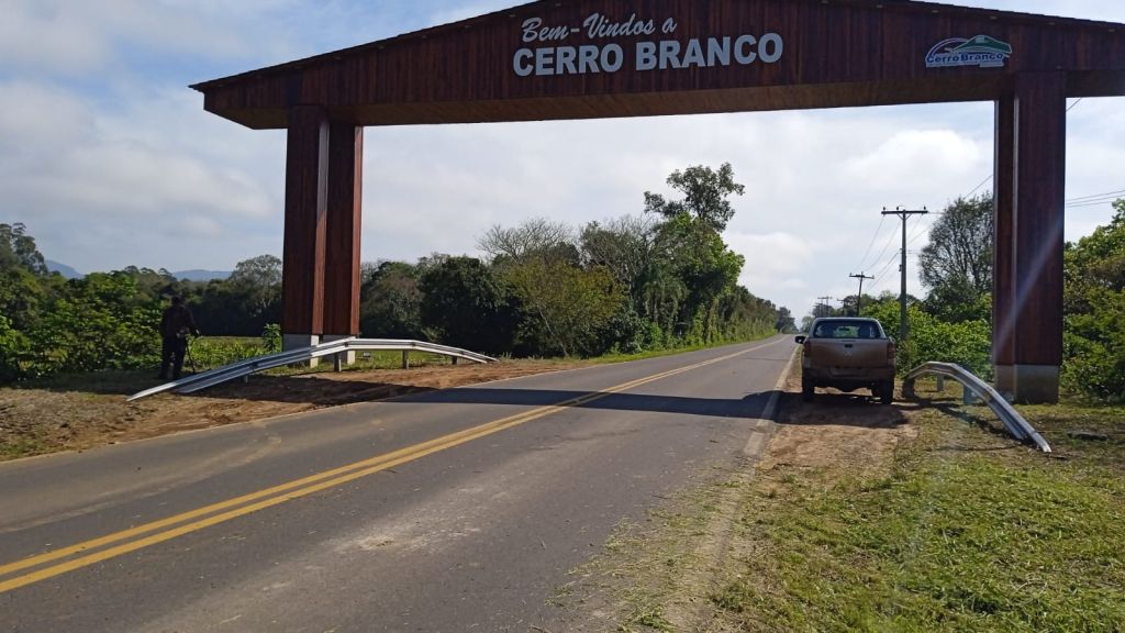 Portal de acesso a Cerro Branco, com vegetação e estrada ao fundo