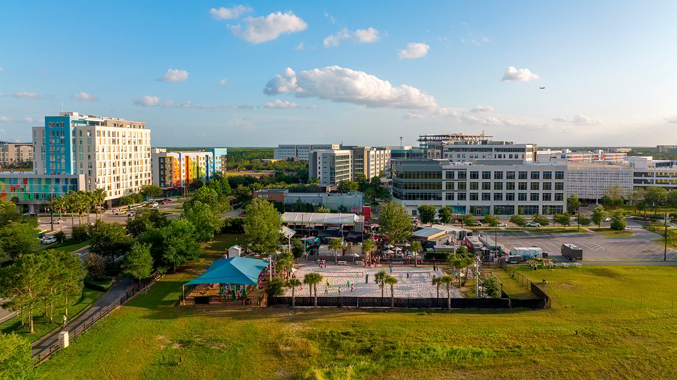 Vista do campus universitário da FURG, com prédios modernos e área verde; estudantes caminham ao ar livre.